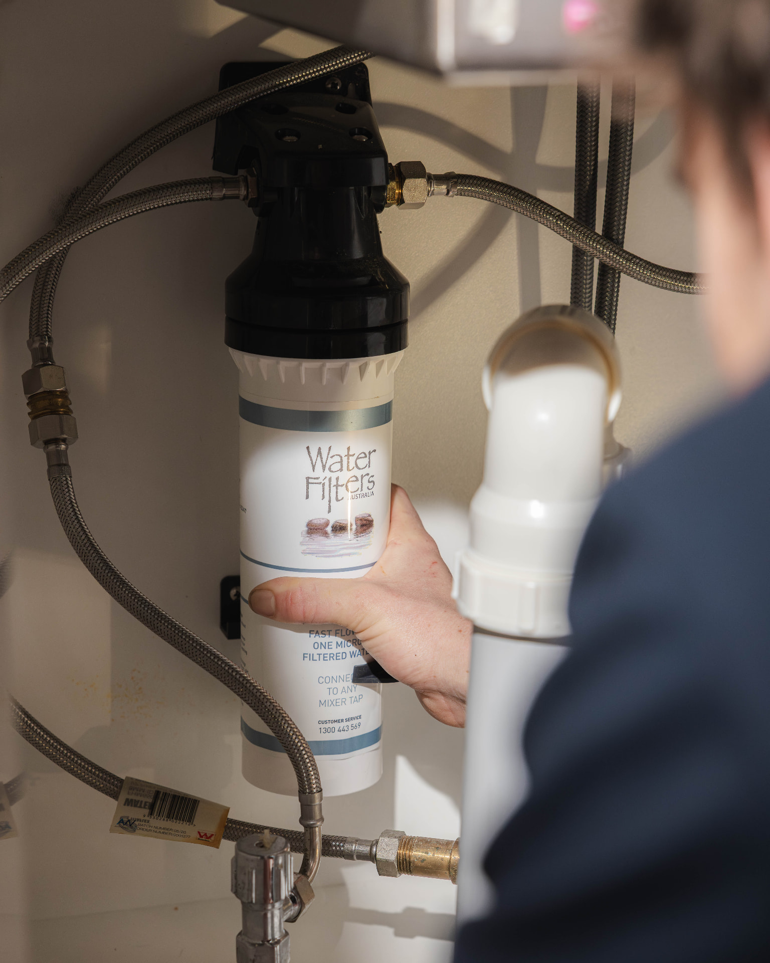 Fixara plumber replacing an under sink water filter cartridge
