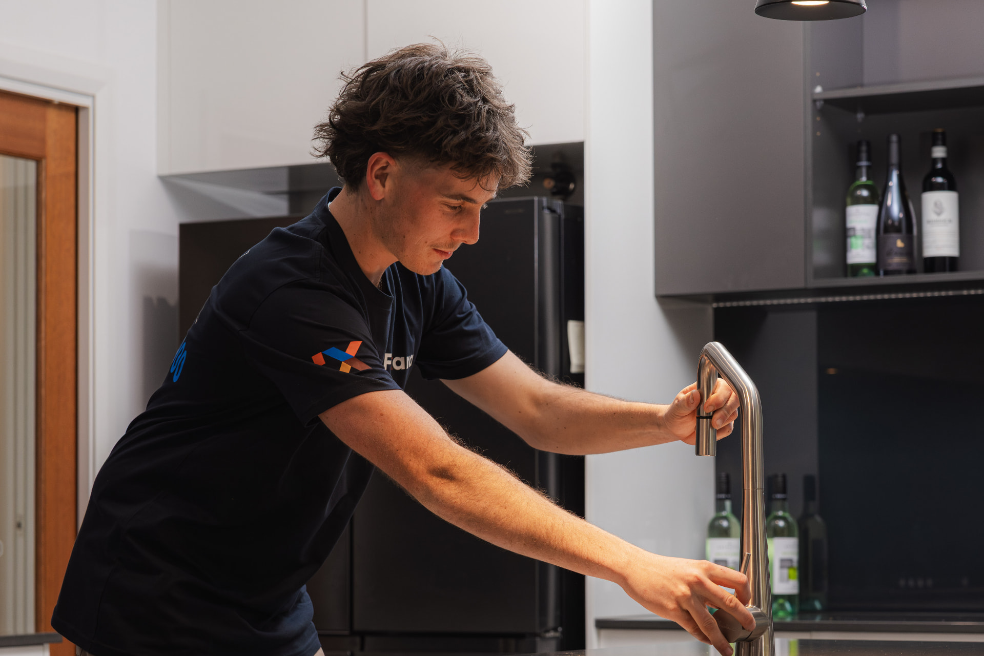 Fixara plumber testing a new chrome kitchen mixer tap