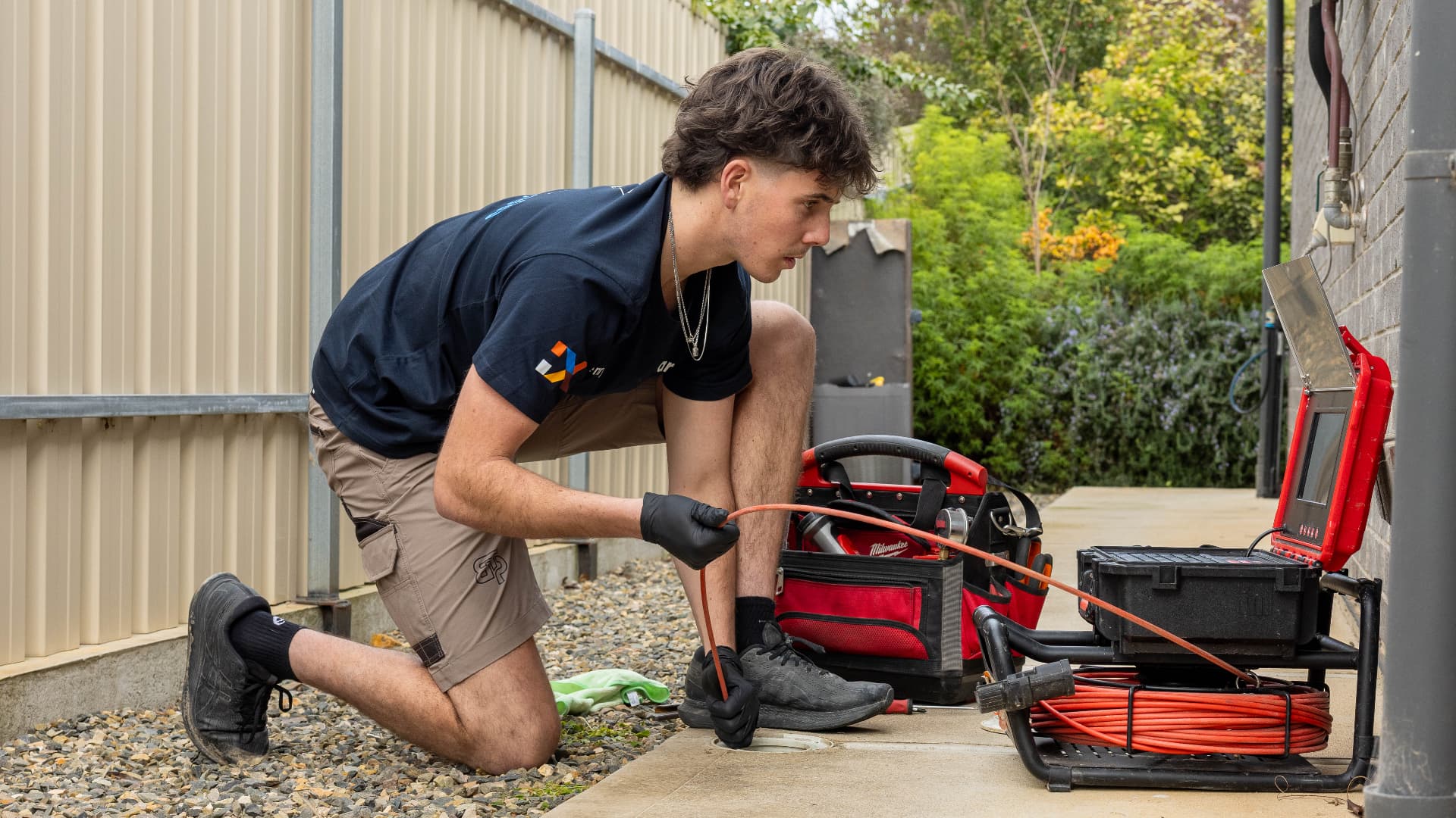 Fixara plumber feeding a CCTV drain camera down a sewer access point