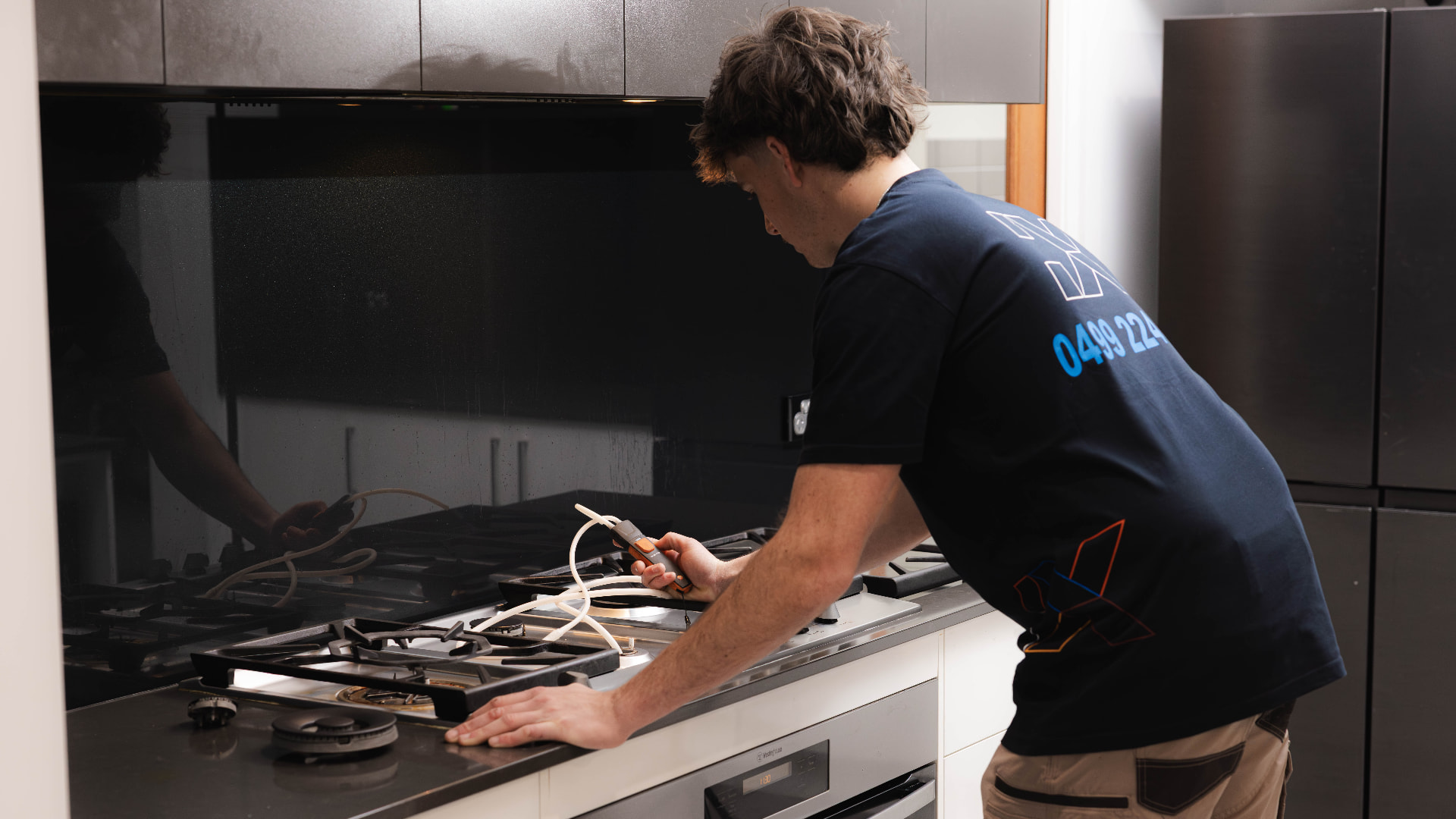 Fixara plumber leak testing a gas cooktop in an Adelaide kitchen